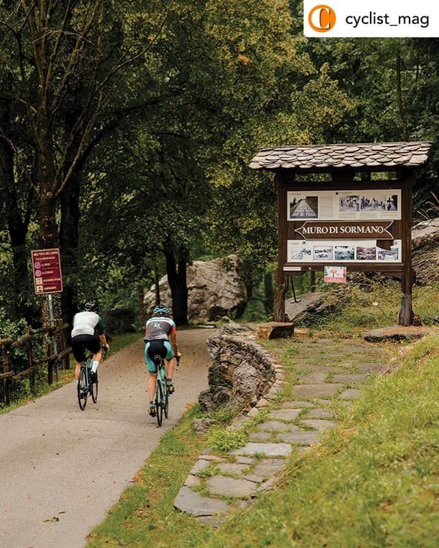 Two cyclists on a winding road in the mountains